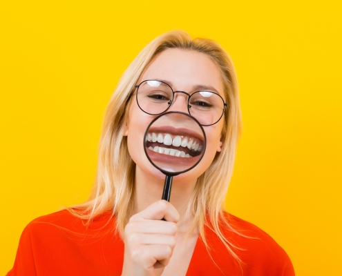 Blonde woman in dress with magnifying glass