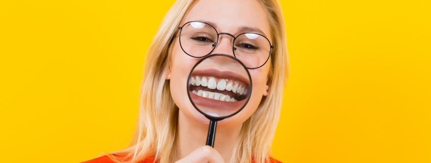 Blonde woman in dress with magnifying glass